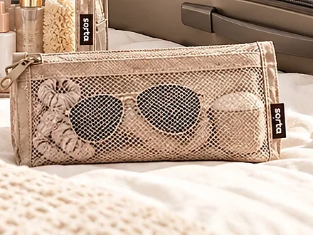 A small mesh pouch holding sunglasses and hair ties.