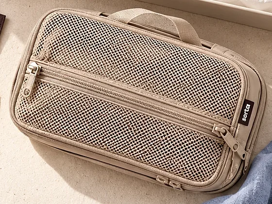 A mesh cube from above, showing the fabric handle and two zips.