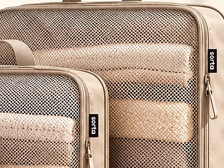 Close-up of a mesh panel with rolled clothing visible behind it.